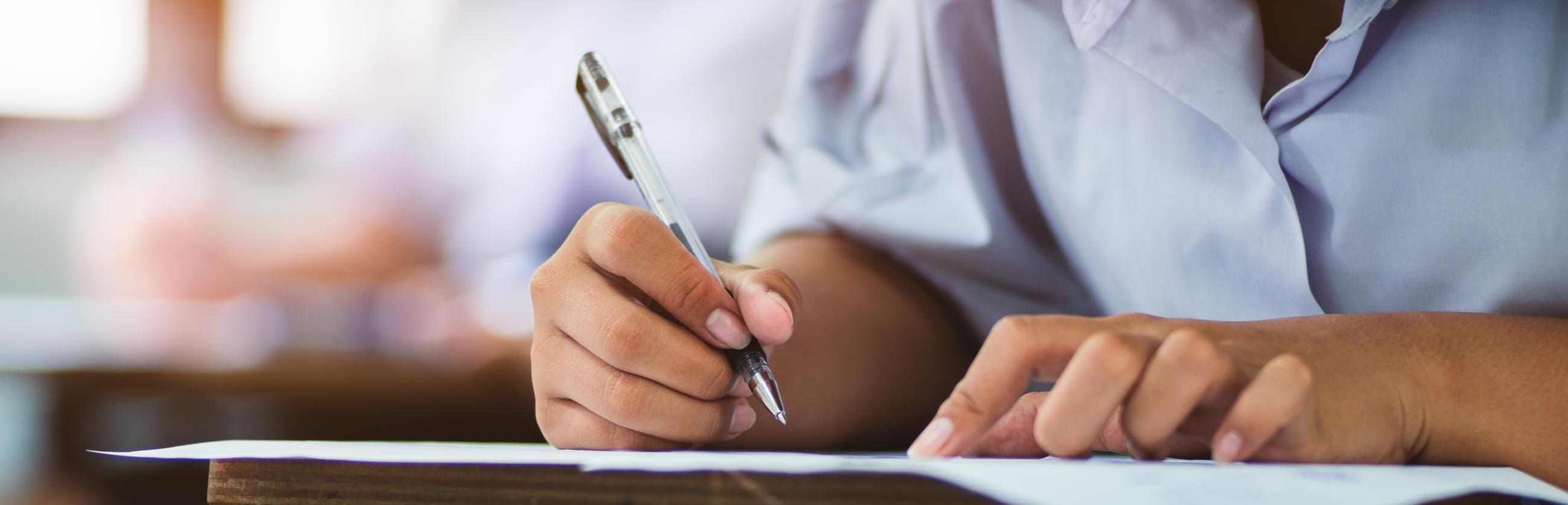 Apprenante stylo à la main en train d'écrire sur une feuille